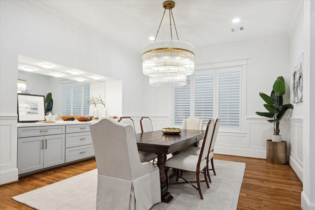 dining room featuring ornamental molding, an inviting chandelier, and hardwood / wood-style flooring