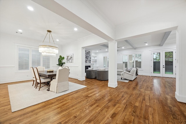 dining room with hardwood / wood-style flooring, a chandelier, french doors, crown molding, and beamed ceiling