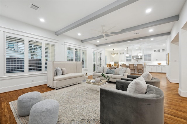 living room featuring hardwood / wood-style flooring, ceiling fan, and beamed ceiling