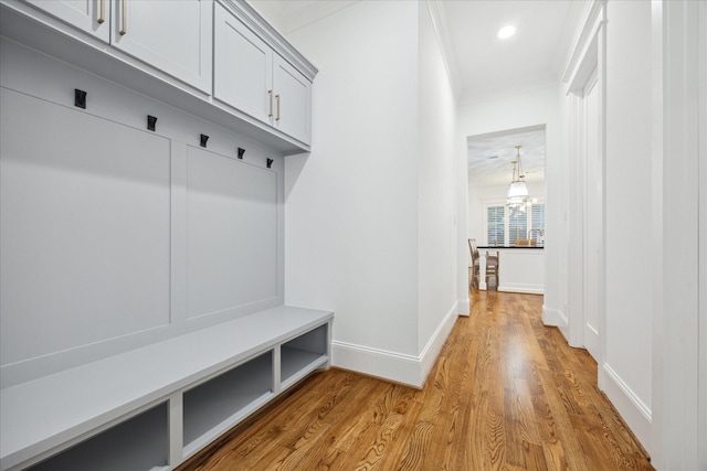 mudroom with ornamental molding and light wood-type flooring