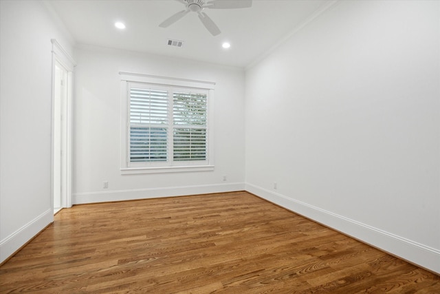 empty room with ceiling fan, crown molding, and wood-type flooring