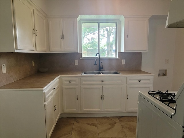 kitchen featuring sink, white cabinetry, gas range gas stove, and tasteful backsplash