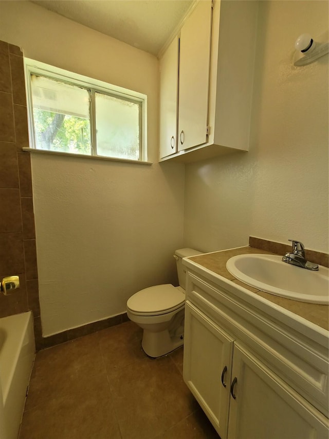 bathroom with toilet, tile patterned flooring, and vanity