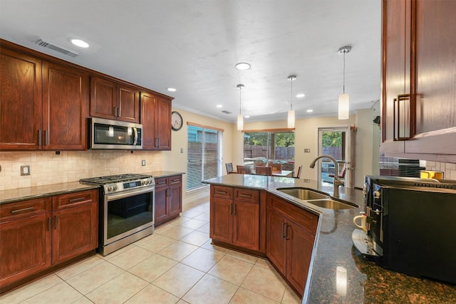 kitchen with sink, backsplash, hanging light fixtures, and appliances with stainless steel finishes