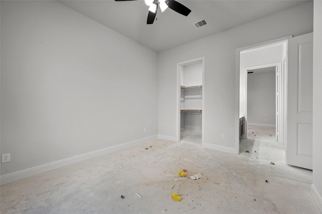 unfurnished bedroom with a walk in closet, ceiling fan, and a closet