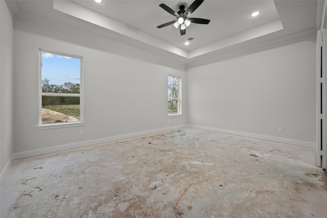 spare room featuring ceiling fan, a tray ceiling, and crown molding