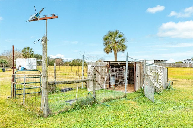 view of outbuilding with a rural view and a lawn