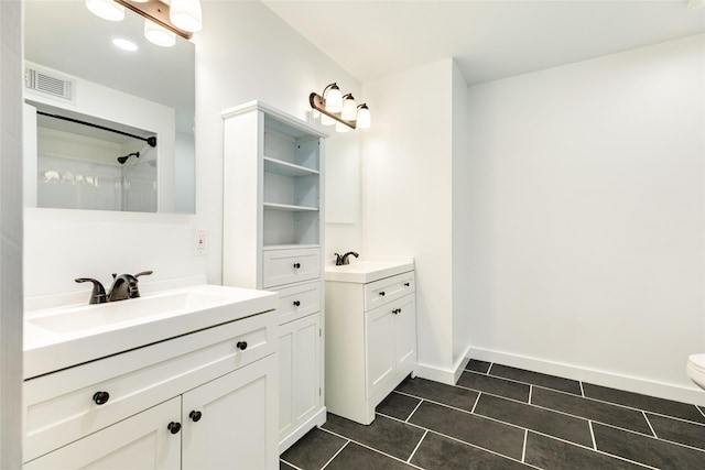 bathroom featuring vanity, toilet, walk in shower, and tile patterned floors