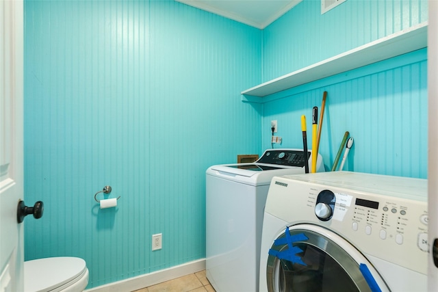 clothes washing area featuring washer and dryer, light tile patterned floors, and crown molding