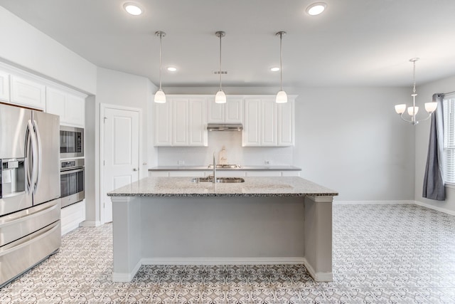 kitchen with decorative light fixtures, light stone countertops, appliances with stainless steel finishes, and white cabinets