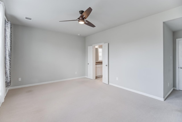 unfurnished bedroom featuring ensuite bath, light carpet, and ceiling fan