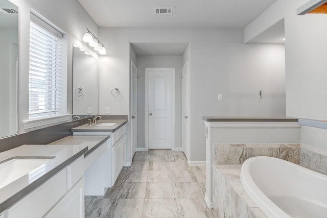 bathroom with vanity and tiled bath