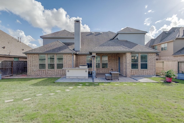 back of house with a patio, a lawn, and a fire pit