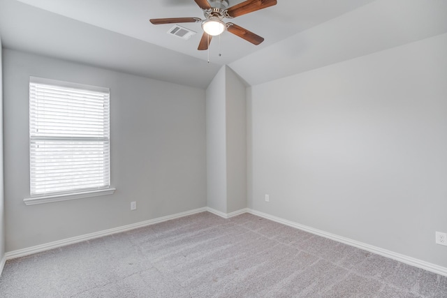 spare room featuring ceiling fan, light colored carpet, and lofted ceiling