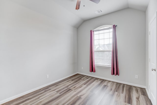 spare room with ceiling fan, light hardwood / wood-style flooring, and vaulted ceiling