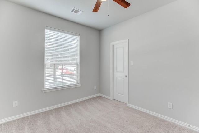 empty room with a healthy amount of sunlight, light colored carpet, and ceiling fan