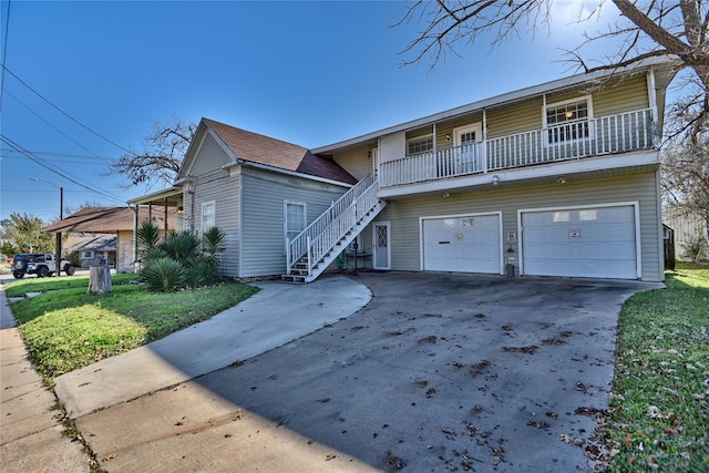 view of front of house featuring a balcony, a front lawn, and a garage