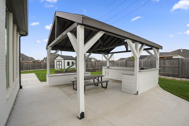 view of patio with a gazebo, a playground, and a storage unit