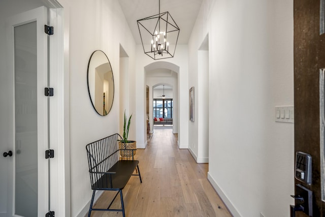 hall with a notable chandelier and light wood-type flooring