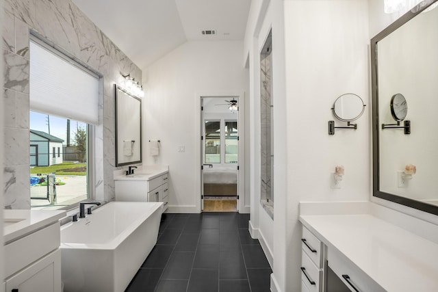 bathroom featuring a washtub, tile patterned floors, vanity, ceiling fan, and lofted ceiling