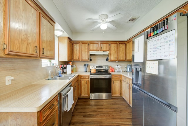 kitchen featuring stainless steel appliances, sink, a textured ceiling, ceiling fan, and dark hardwood / wood-style floors