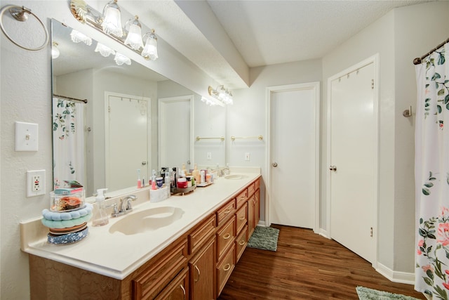 bathroom featuring a textured ceiling, wood-type flooring, and vanity