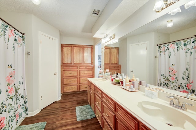 bathroom featuring a textured ceiling, a shower with shower curtain, wood-type flooring, and vanity