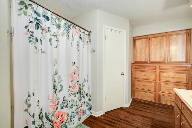 bathroom with a textured ceiling, hardwood / wood-style floors, and vanity