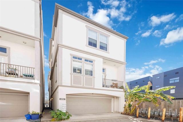 townhome / multi-family property featuring a balcony and a garage