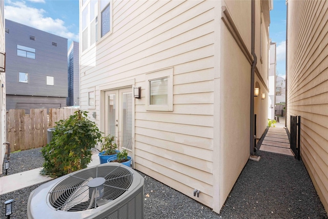 view of property exterior featuring fence and central AC