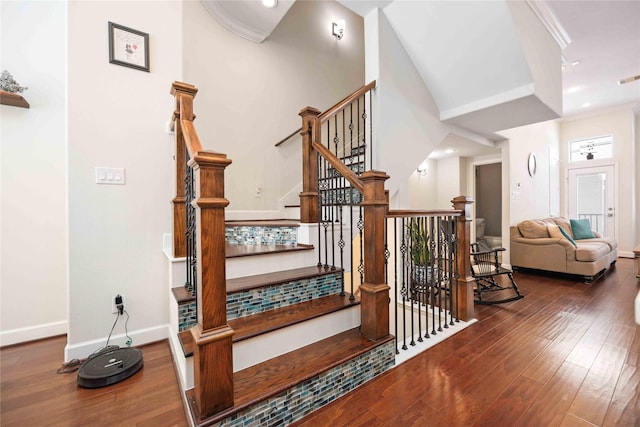 stairway featuring ornamental molding, wood finished floors, visible vents, and baseboards