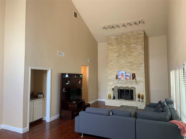 living room featuring high vaulted ceiling and a brick fireplace