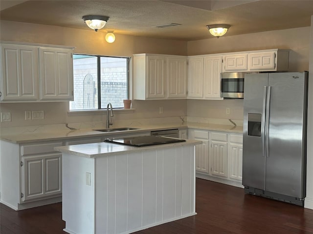 kitchen with visible vents, appliances with stainless steel finishes, dark wood-style floors, white cabinets, and a sink