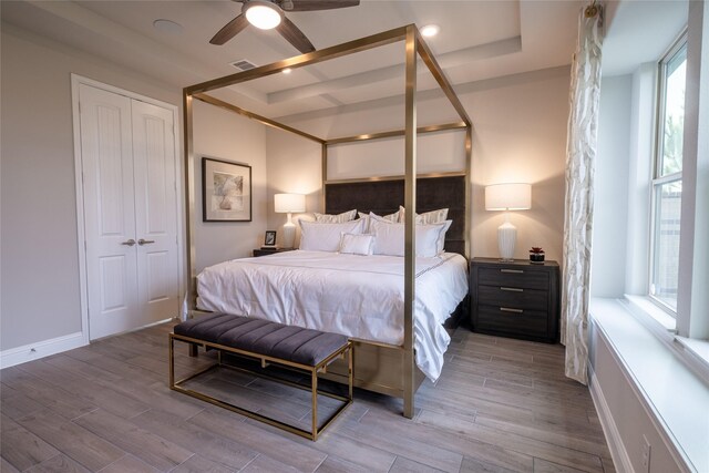 bedroom with ceiling fan, a closet, and multiple windows