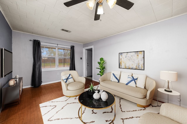 living room featuring wood-type flooring, ceiling fan, and crown molding