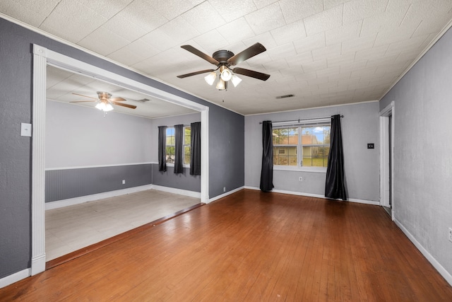 unfurnished room with ceiling fan, hardwood / wood-style flooring, and crown molding