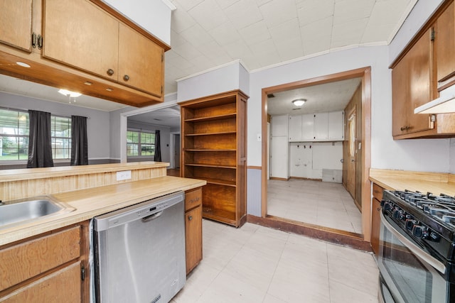 kitchen with stainless steel appliances, ornamental molding, and sink