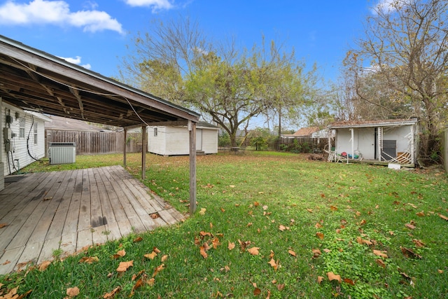 view of yard with a deck, central air condition unit, and a storage shed