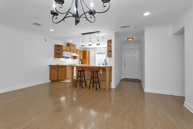227 Crest Hill Dr, Conroe, TX 77301 - kitchen featuring open shelves, a chandelier, a breakfast bar area, white microwave, and baseboards