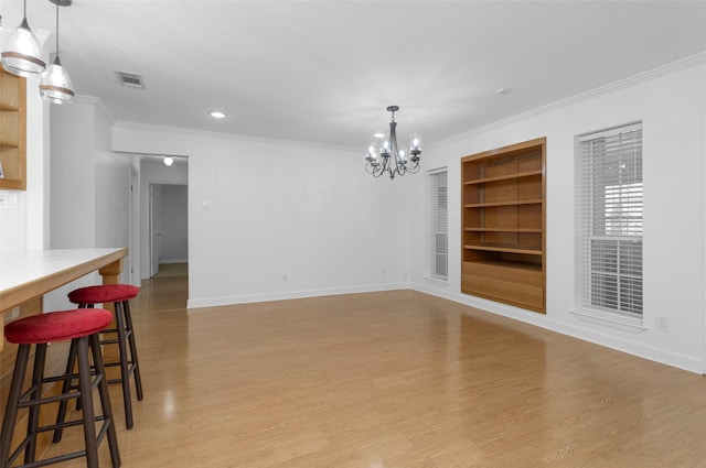 227 Crest Hill Dr, Conroe, TX 77301 - unfurnished dining area with built in shelves, ornamental molding, a chandelier, light wood-style floors, and baseboards