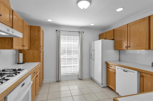 227 Crest Hill Dr, Conroe, TX 77301 - kitchen featuring white appliances, tile countertops, tasteful backsplash, healthy amount of natural light, and crown molding