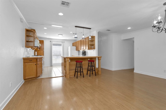 kitchen with white appliances, light wood-type flooring, ornamental molding, and backsplash