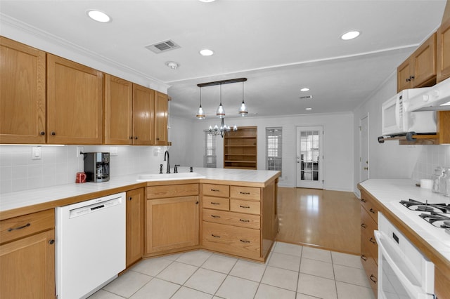 kitchen featuring white appliances, crown molding, kitchen peninsula, sink, and backsplash