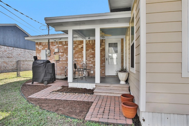 view of exterior entry featuring ceiling fan