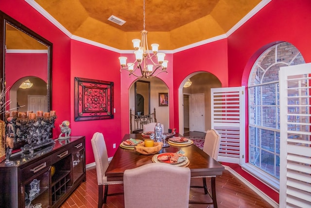 dining area featuring a raised ceiling and a chandelier