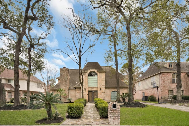 view of front of home featuring central AC unit and a front yard