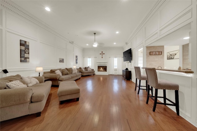 living room with light wood-type flooring and crown molding