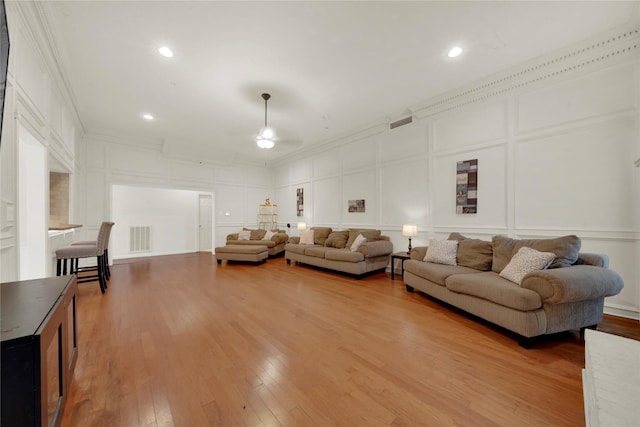 living room with wood-type flooring and ornamental molding