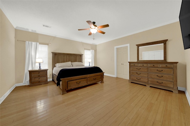 bedroom with a closet, ceiling fan, crown molding, and light wood-type flooring