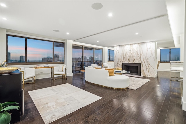 living room with a high end fireplace and dark hardwood / wood-style floors